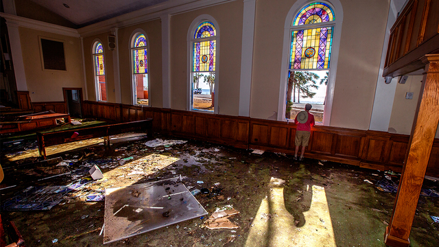 Pastor Geoffrey Lentz looks out at St Joe Bay from his sanctuary of the First United Methodist Church after it was gutted by the storm surge from Hurricane Michael on October 14, 2018 in Port Saint Joe, Florida (Photo by Mark Wallheiser/Getty Images)