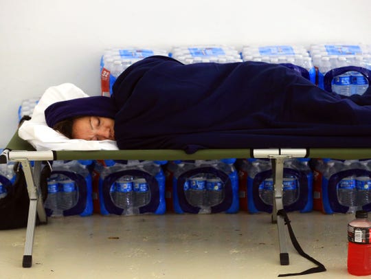 A woman sleeps on a cot after she evacuated to a shelter after Hurricane Harvey landed in the Coastal Bend area on Saturday, Aug. 26, 2017, in Port Aransas, Texas.