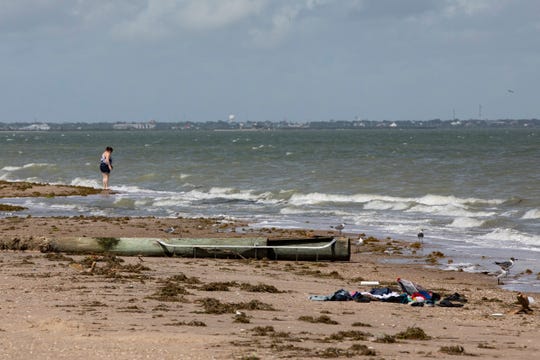 A women stands to the beach on North Beach City crews Monday, July 27, 2020 two days after Hurricane Hanna.