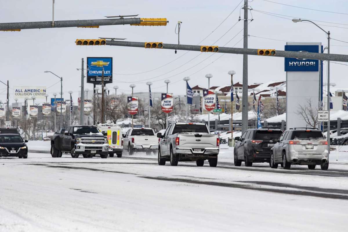 Ice and snow blanket parts of a Grandview Avenue and Charles Walker Road, Monday, Feb. 15, 2021 in Odessa, Texas. A sprawling blast of winter weather across the U.S. plunged Texas into an unusually snowy emergency Monday that knocked out power for more than 2 million people, shut down grocery stores and air travel and closed schools ahead of frigid days still to come. (Jacob Ford/Odessa American via AP)