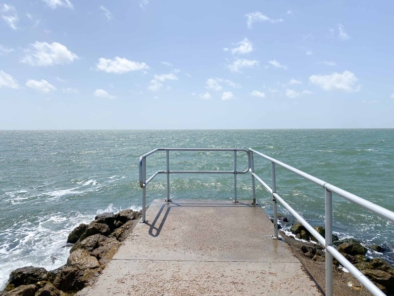 A concrete pier next to Rockport Beach faces Aransas Bay.